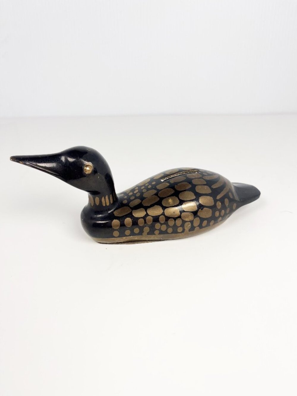 Small brass painted loon coin bank - black and bronze